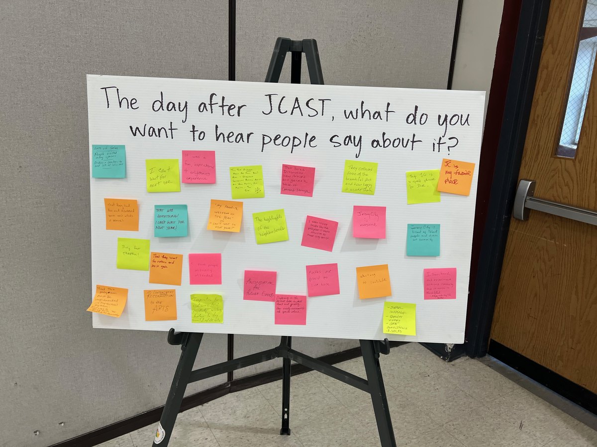 Easel board reading 'The day after JCAST, what do you want to hear people say about it?' covered in sticky notes.