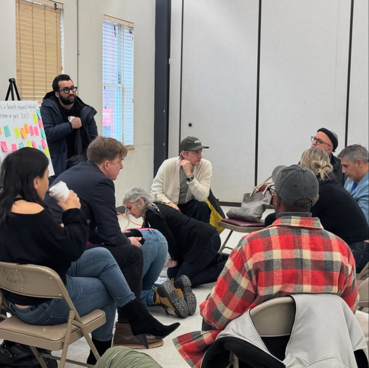 Participants seated in a circle of folding chairs during a group discussion at the forum.