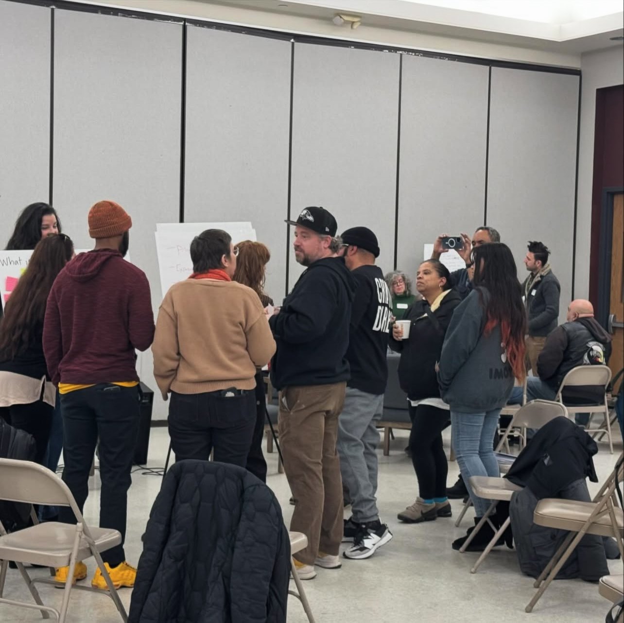 Participants standing in small clusters between working sessions.